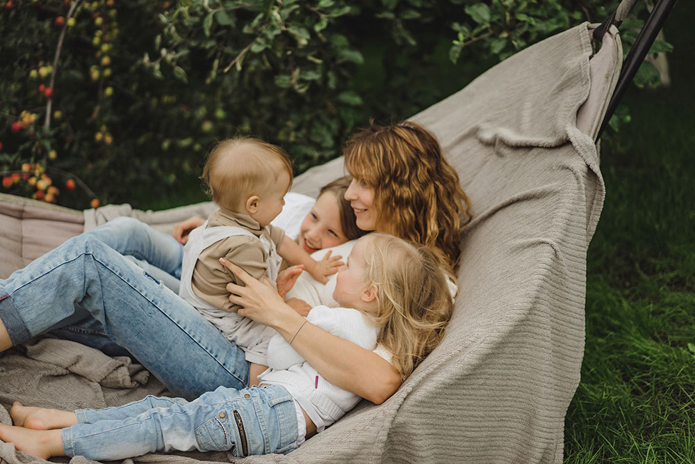 mother with children having fun in a hammock. Mom and kids in a