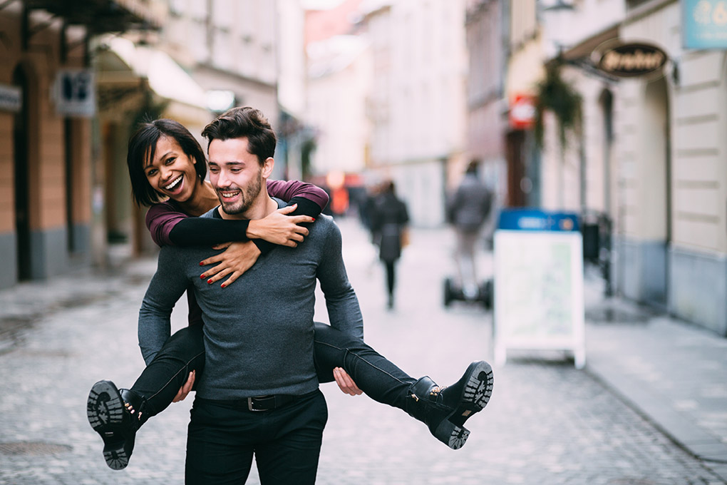 Young man giving girlfirend piggyback ride